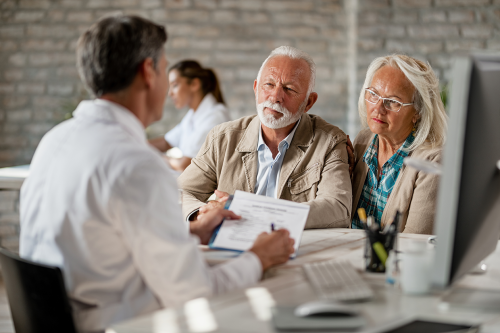 senior couple consulting with healthcare worker